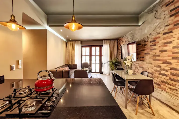 Open kitchen with gas hob looking across the dining table to the living room