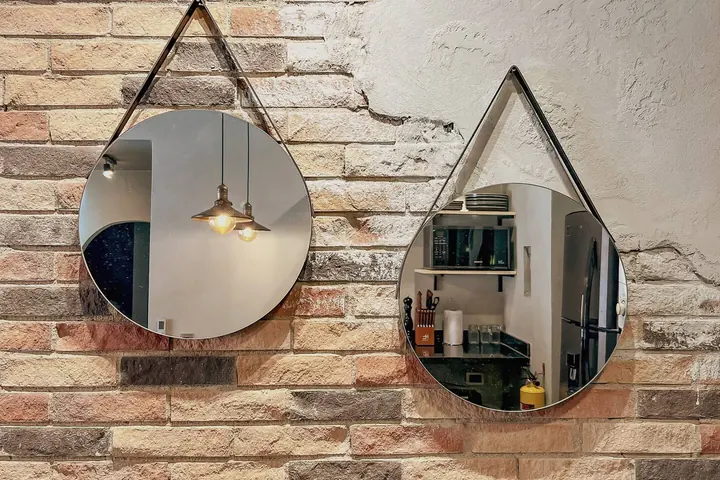 Two round mirrors hanging on the brick wall