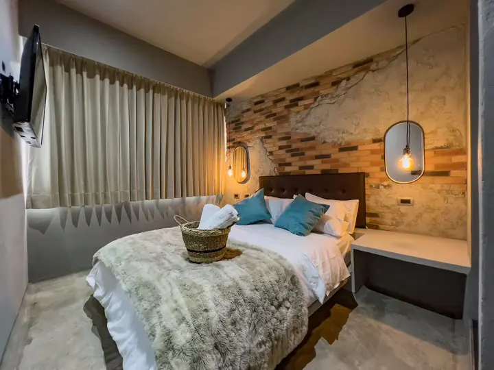Bedroom with a large bed, curtains and a pendant lamp