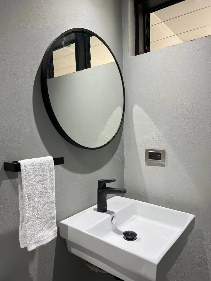 Basin with a round mirror and towel rail