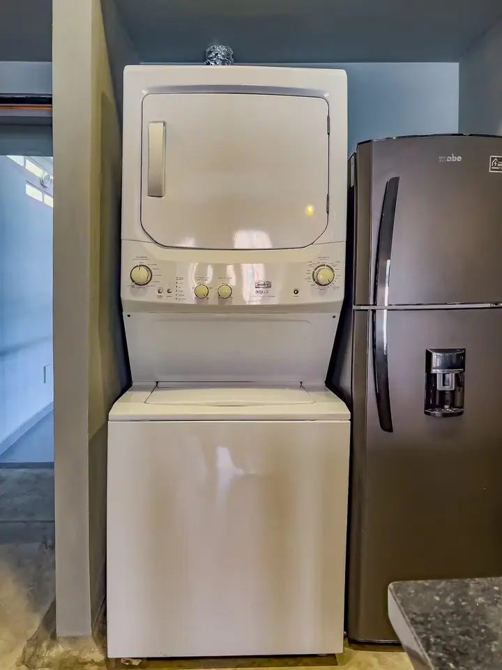 Stacked washer and dryer next to the fridge