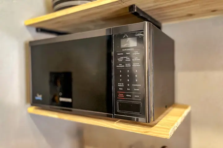 Microwave on a wooden shelf