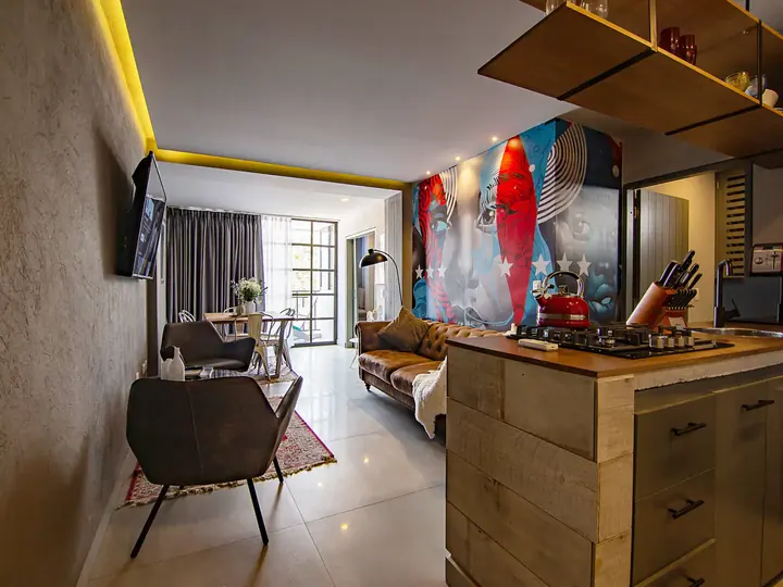 Open kitchen with island looking towards the living room and mural