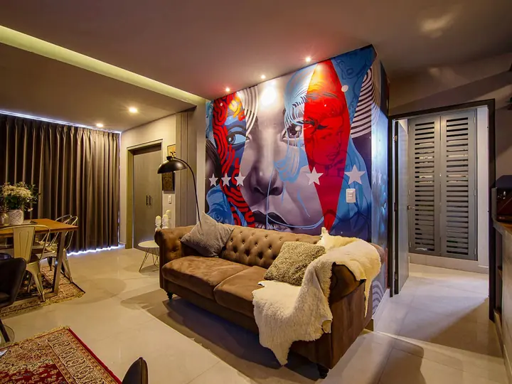 Living room with mural wall, leather sofa and dining area