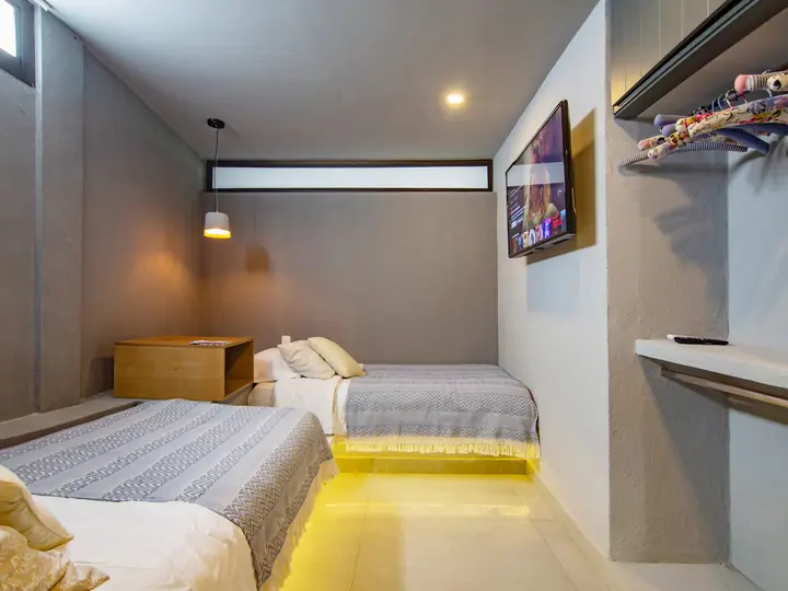 Bedroom with two single beds and a wall-mounted TV