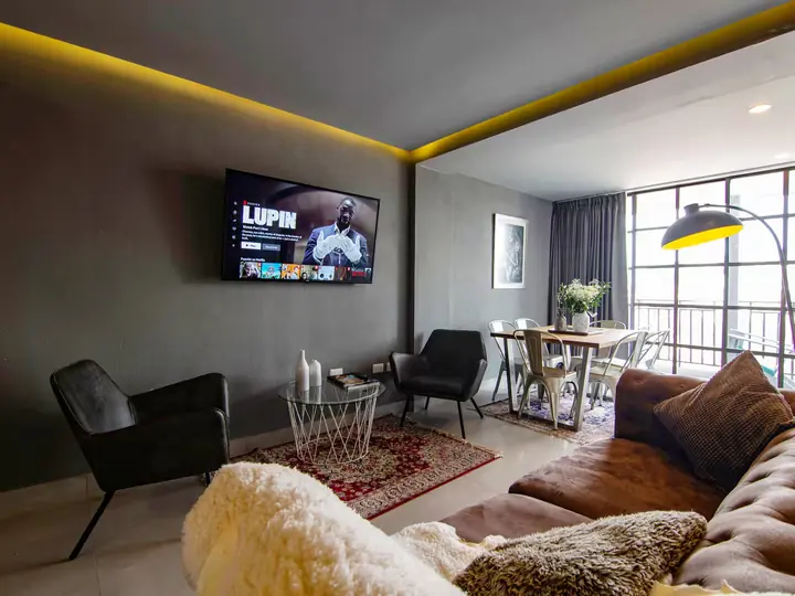 Living room with TV, floor lamp and dining table by the window