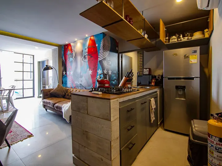 Kitchen with wooden island, fridge and hanging shelves