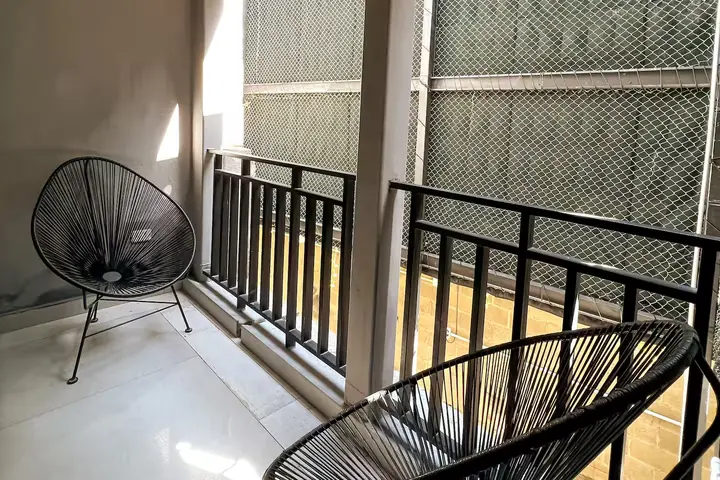 Private balcony with two black Acapulco chairs