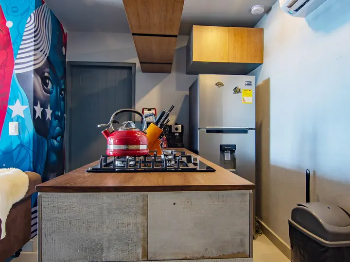 Kitchen island with gas hob and red kettle