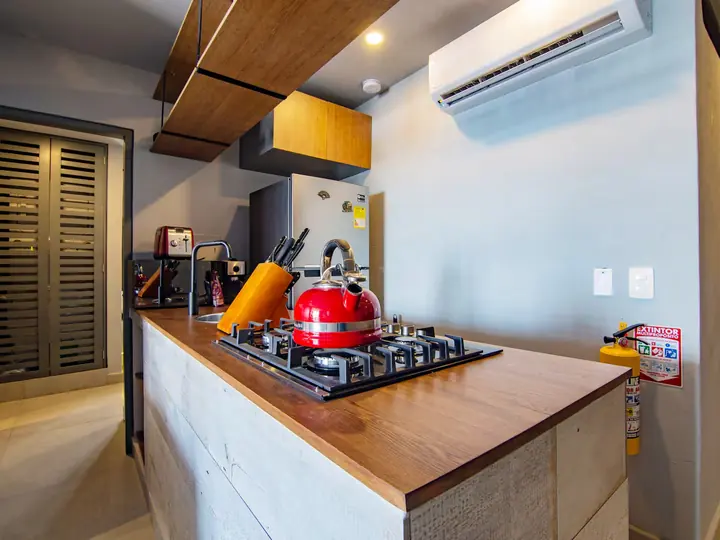 Kitchen worktop with gas hob, knife block and air conditioning above