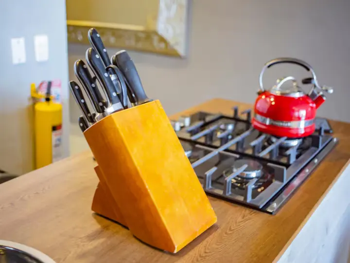 Gas hob with red kettle and knife block