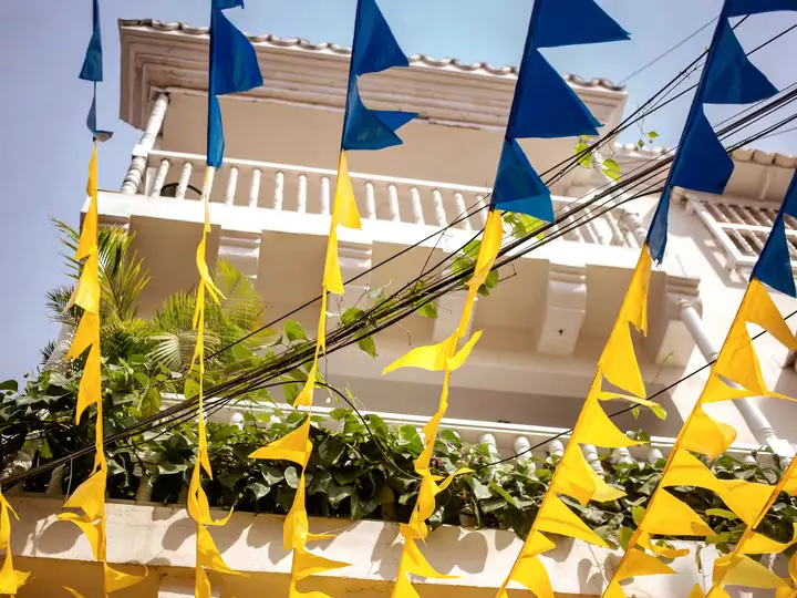 Building façade with white balconies and yellow and blue bunting